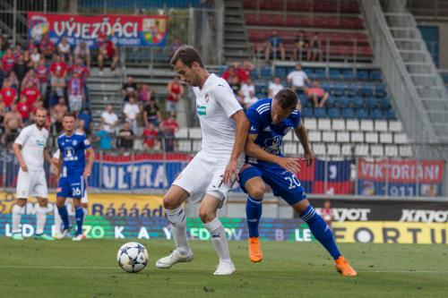 Tomáš Hořava drží balón před Faltou a v pozadí vše sledují  Nešpor s Hubníkem